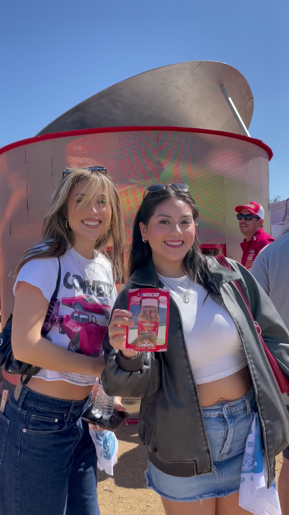 Fans with La Costeña samples in front of a giant jalapeño can at a NASCAR race